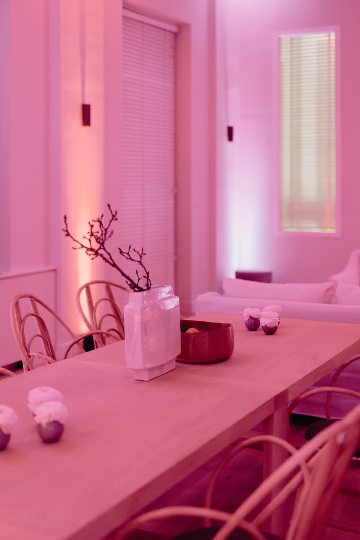 A long table set for an evening, in soft pink light